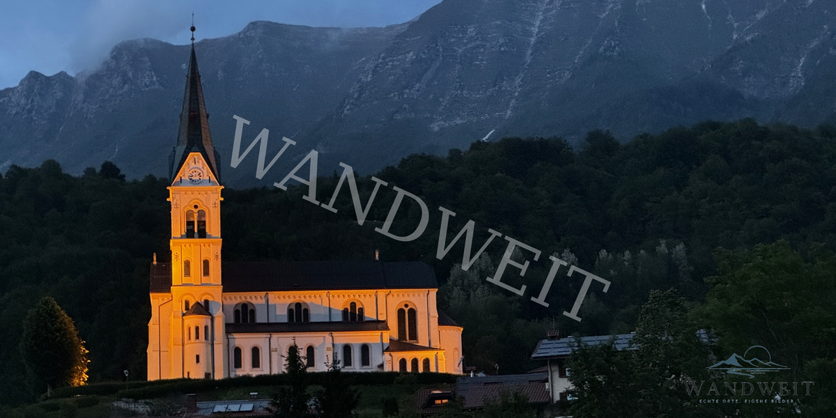 Beleuchtete Kirche vor Bergen – WANDWEIT Vorschau mit Wasserzeichen